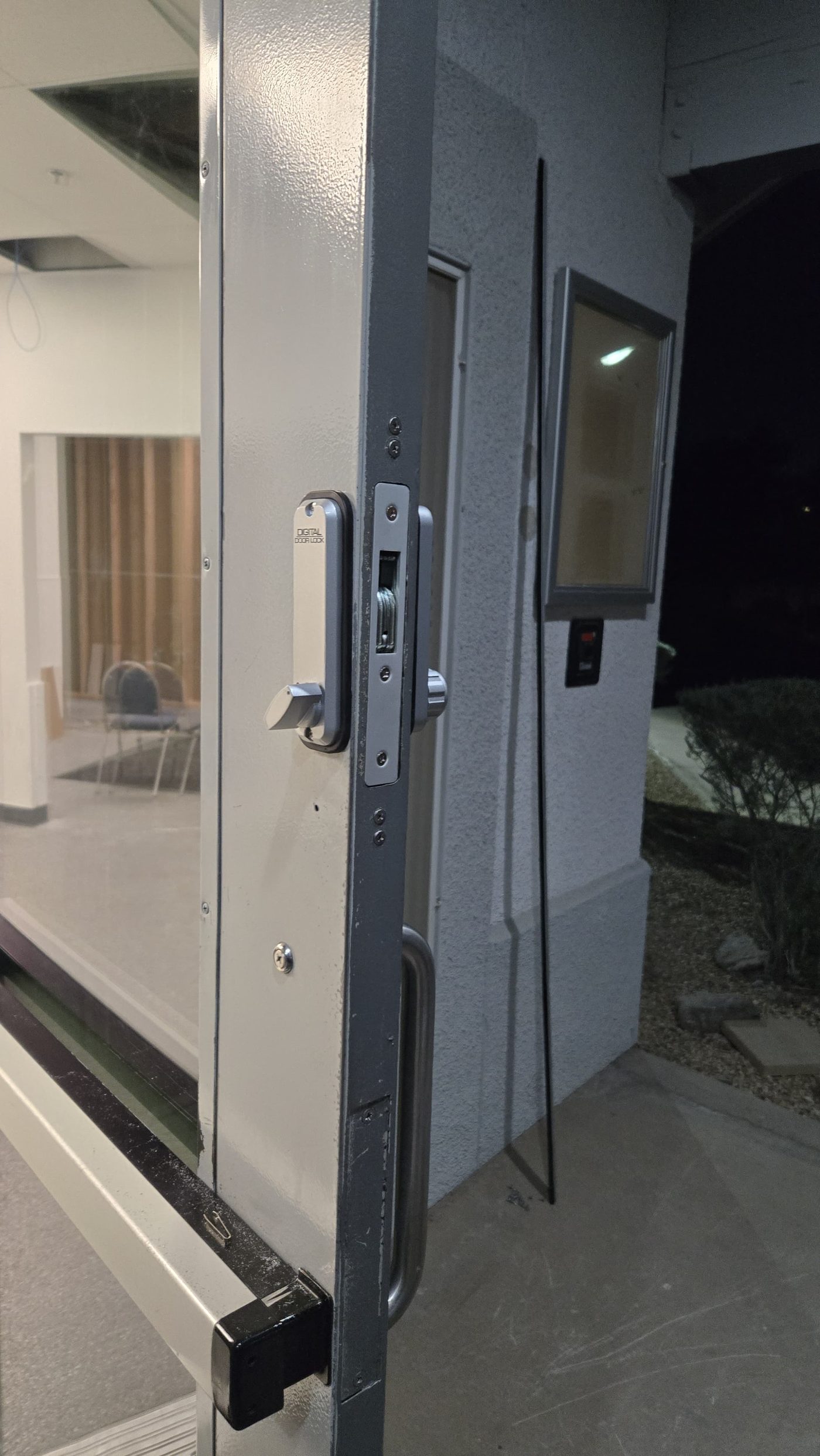 Digital door lock installed on a commercial glass entry door