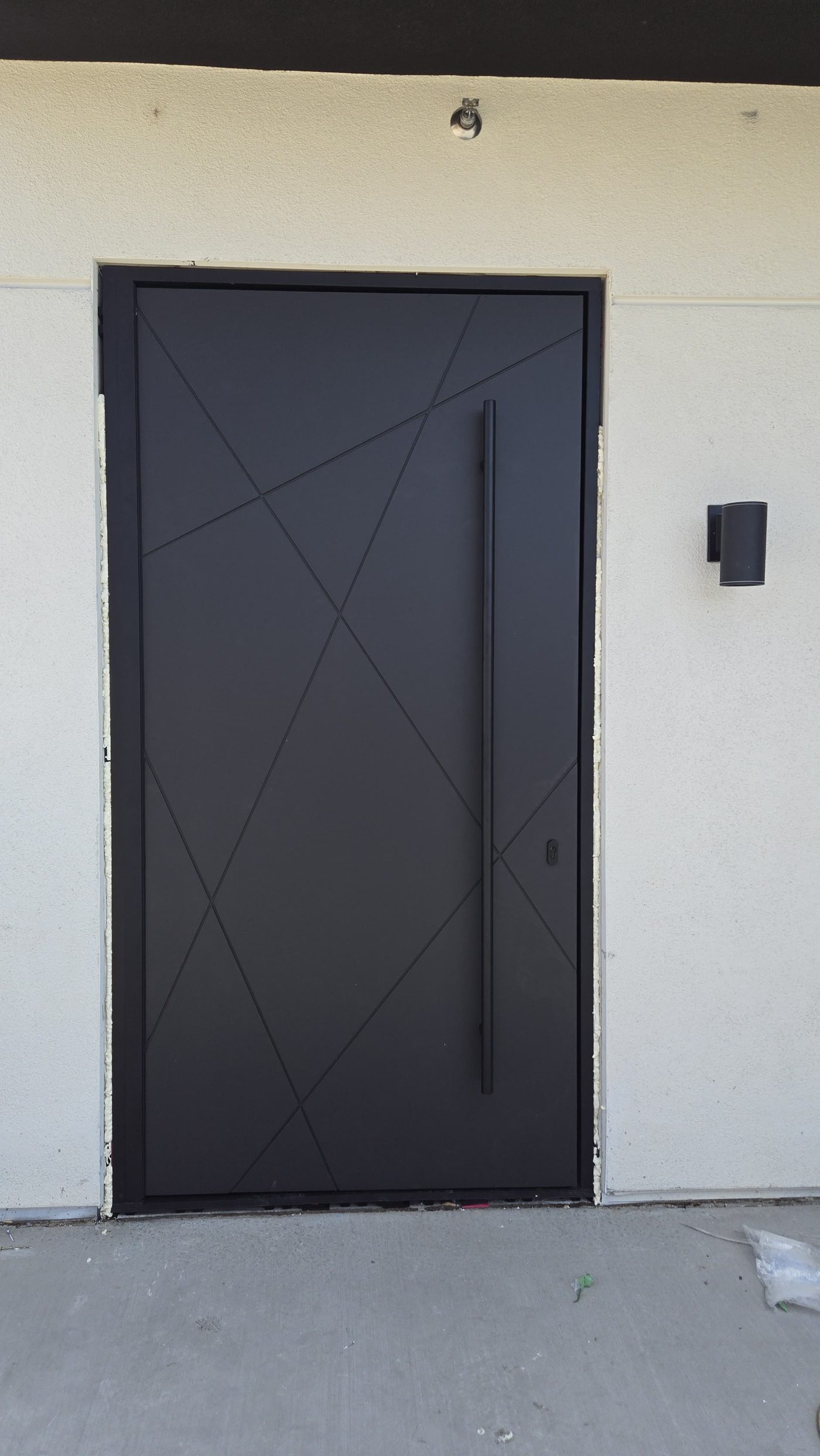 Completed custom Panda pivot door with a diagonal line pattern